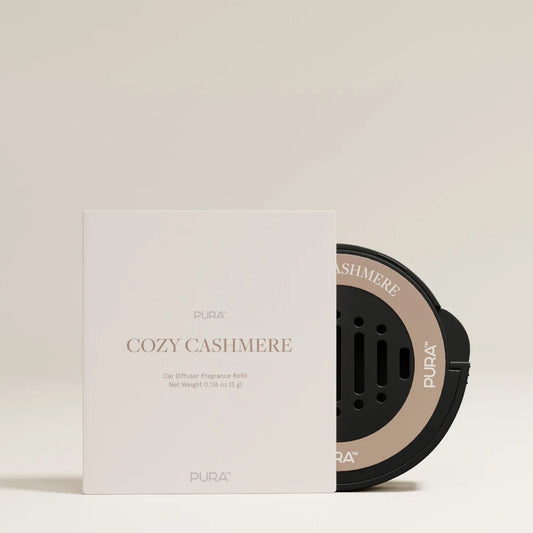 PURA Cozy Cashmere car diffuser fragrance refill shown with its white box packaging on a warm beige background.