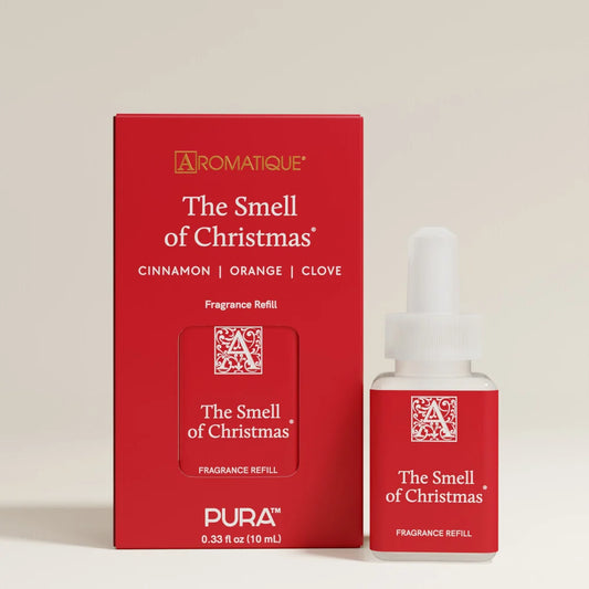 A Pura Aromatique fragrance refill set featuring a red box and a small glass dropper bottle labeled 'The Smell of Christmas' on a light beige background.
