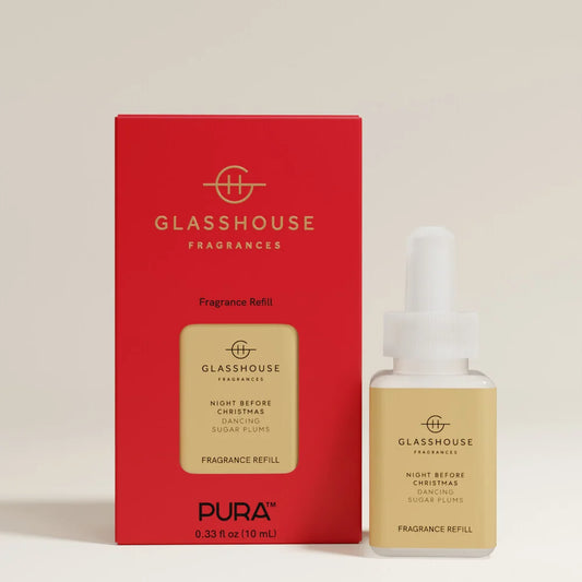 A bottle of Glasshouse Fragrances 'Night Before Christmas' sugar plums fragrance refill next to its red packaging box on a light beige background.