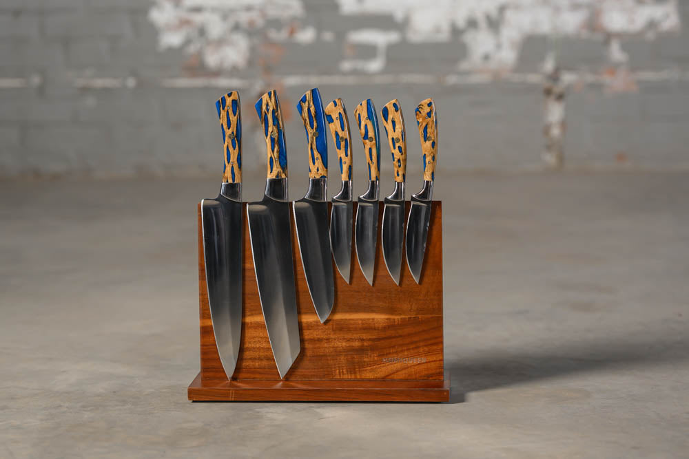 STS Kitchen knives Cholla cactus with blue inlay on wooden block with blurred industrial background