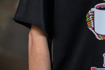 Close-up of a person wearing a black short-sleeve T-shirt with a colorful graphic print on the side, showing the arm and torso.