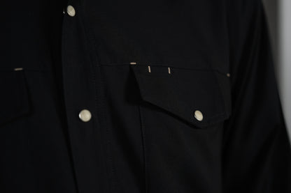 Detail of the black GameGuard Stockyard Shirt chest pocket with snap closure and contrast accent stitching