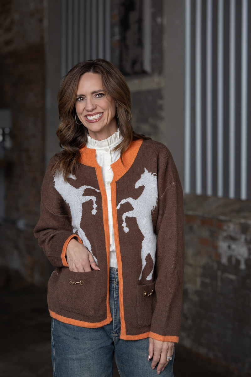 Jennifer Smtih of STS Ranch/1930 Remnant modeling a brown & orange cardigan sweater with a horses detail on front