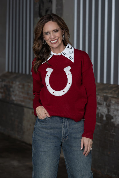Jennifer Smtih of STS Ranch/1930 Remnant modeling a maroon sweater with a horseshoe detail on front with a brand collar at the top