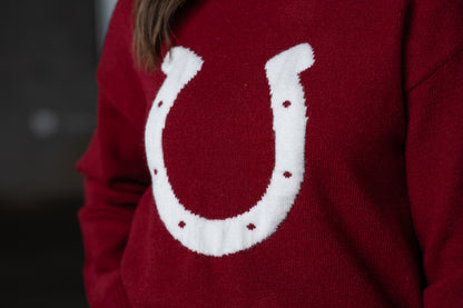 Close up Jennifer Smtih of STS Ranch/1930 Remnant modeling a maroon sweater with a horseshoe detail on front