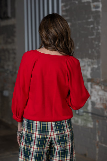 back view Jennifer Smith of STS Ranch and 1930 Remnant modeling a red cardigan sweater paired with Tartan plaid pants by Ivy Jane