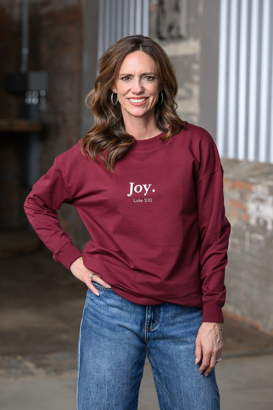 Jennifer Smith of STS Ranch & 1930 Remnant wearing a maroon sweatshirt by Rizen with the words Joy. Luke 2:10 in white.
