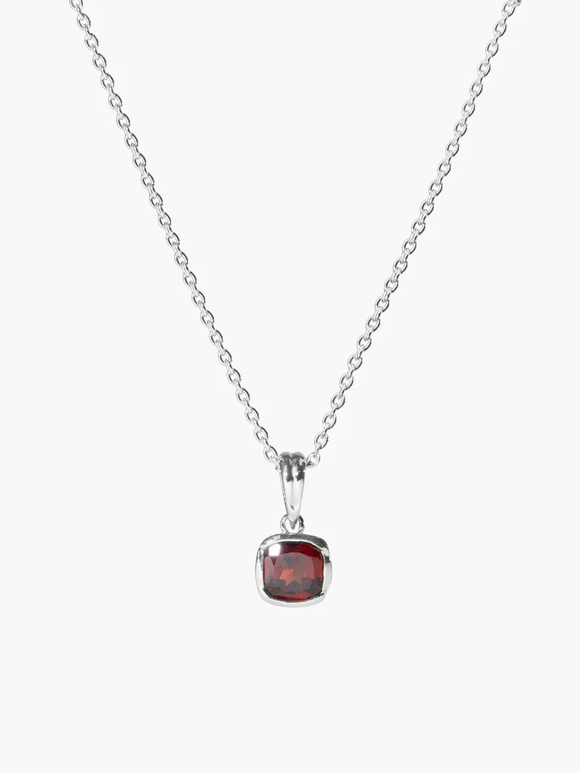 A silver chain necklace with a cushion-cut red gemstone pendant, displayed against a clean white background.