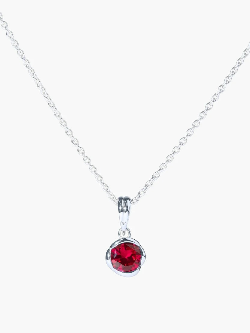 Silver necklace with a red gemstone pendant on a white background