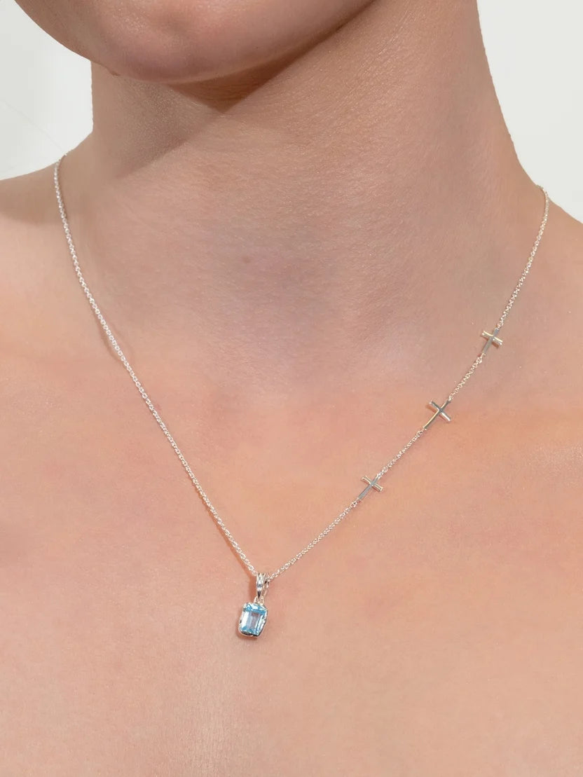 Necklace with a blue gemstone pendant on a person's neck