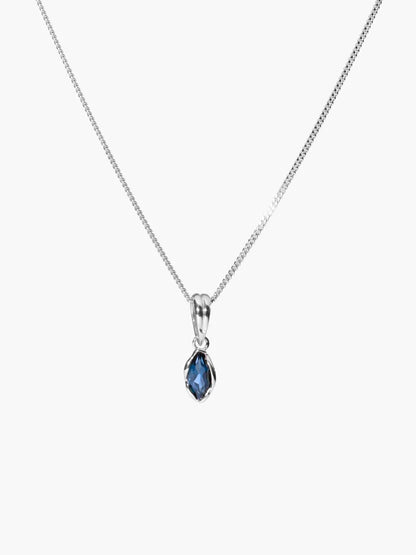 A silver chain necklace with a teardrop-shaped blue gemstone pendant in a silver bezel setting, shown against a plain white background.