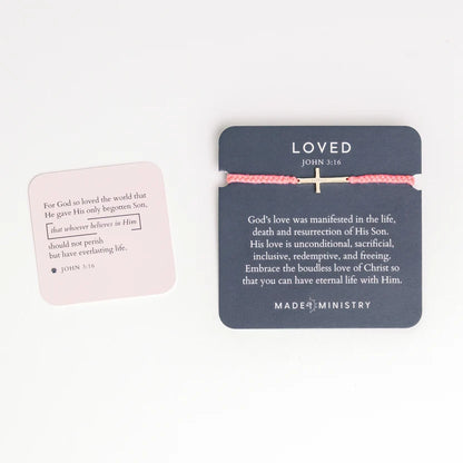 Pink bracelet with a cross on a blue card with text and 'Mader Ministry' branding.