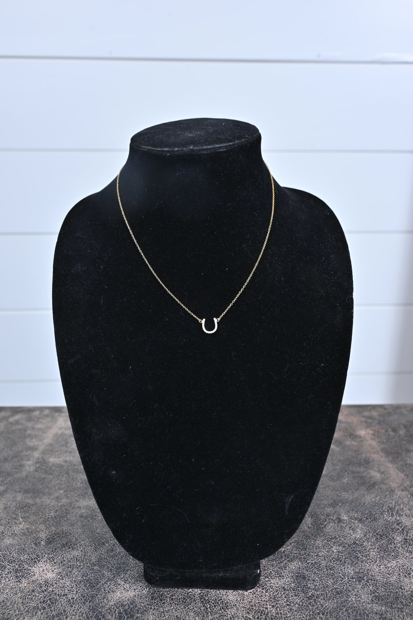 delicate horseshoe necklace in gold on black display