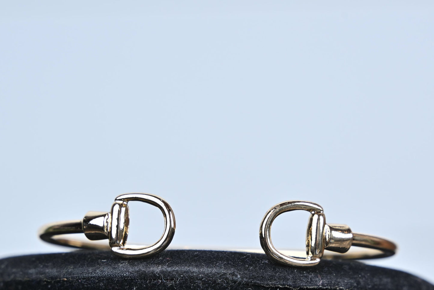 gold stirrup bangle bracelet polished finish close up