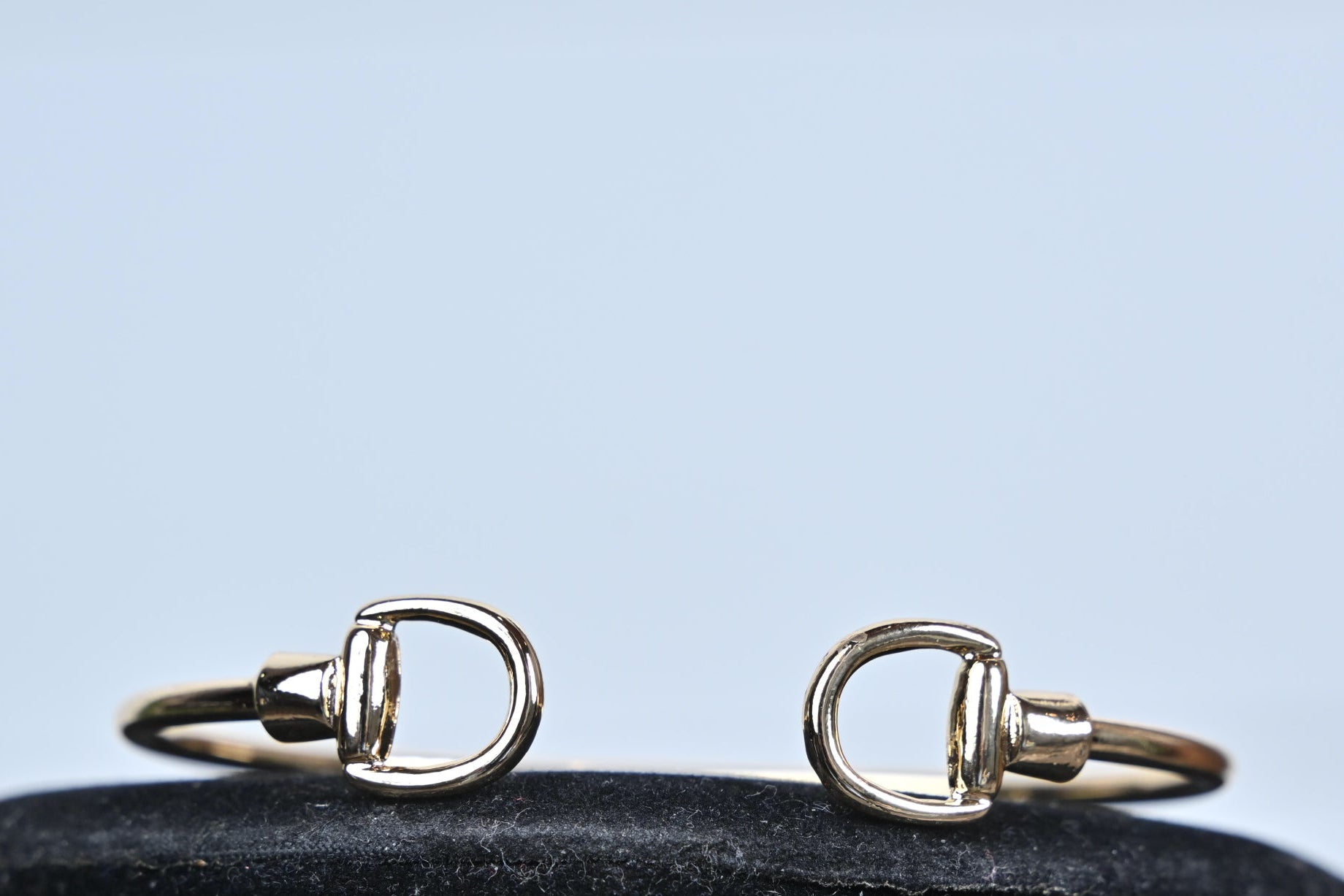 gold stirrup bangle bracelet polished finish close up