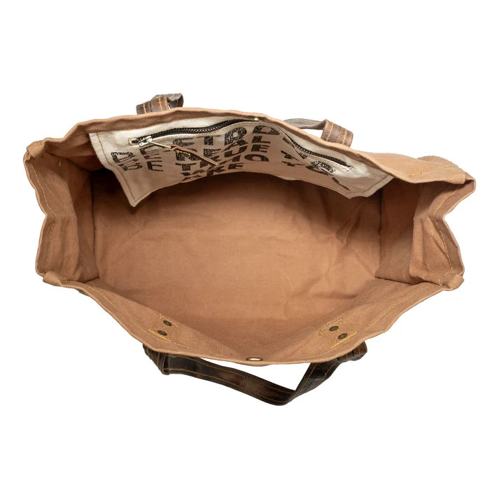 Brown leather bag with visible stitching on a white background