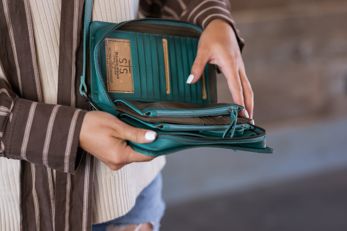 STS Ranchwear Wayfarer Turquoise Evie Organizer open showing card slots, ID window and two zip pouches designed by Jennifer Smith STS Ranch interor on model