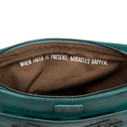Turquoise leather crossbody purse interior  with quote, "When Faith is Present, Miracles Happen."