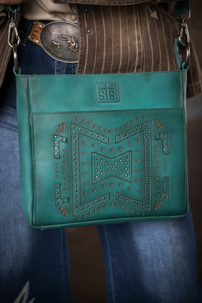 Turquoise leather crossbody purse with studded western design front view on person