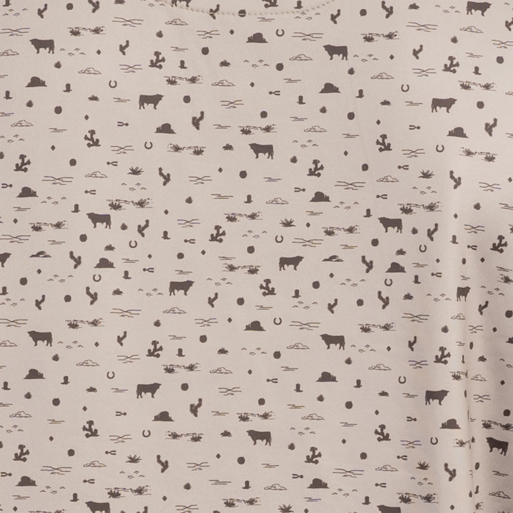 Close-up of desert sand shirt with chocolate western pattern detail