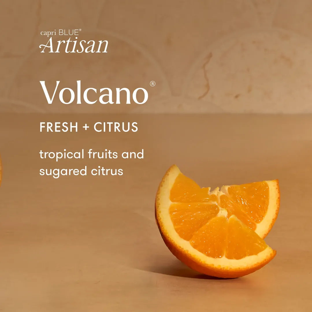 Capri Blue Artisan Volcano Fresh + Citrus flavor graphic with an orange slice on a warm beige background and text describing tropical fruits and sugared citrus.